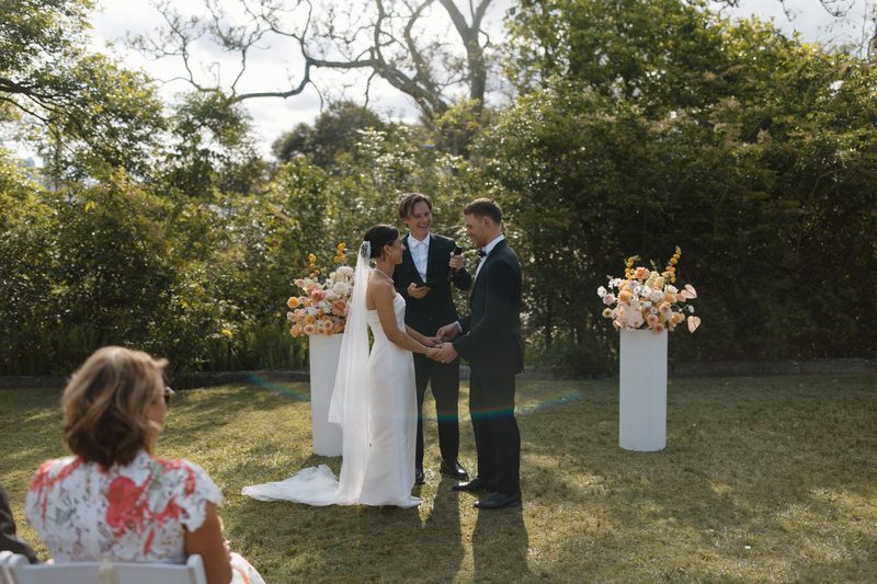 Garden ceremony in full swing between two floral plinths