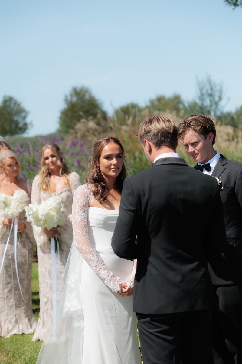 Bride and groom all smiles beside the bridal party